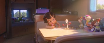 Movie still from “Toy Story 4” (2019), directed by Josh Cooley – A little girl sitting at a table writing on a piece of paper; Wide shot, Over the shoulder angle
