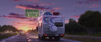 Movie still from “Toy Story 4” (2019), directed by Josh Cooley – A recreational vehicle driving down a highway at sunset; Extreme Wide shot, Low angle