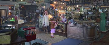 Movie still from “Toy Story 4” (2019), directed by Josh Cooley – Two girls and an older woman in a store; Wide shot, Over the shoulder angle