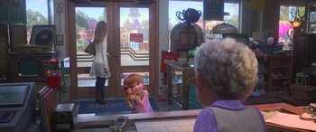 Movie still from “Toy Story 4” (2019), directed by Josh Cooley – A little girl holding a banana in front of an older woman; Wide shot, Over the shoulder angle
