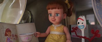 Movie still from “Toy Story 4” (2019), directed by Josh Cooley – A toy doll is holding a cup of coffee; Close Up shot, High angle