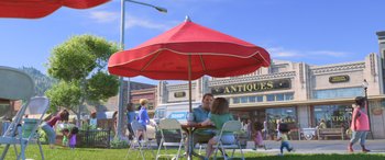 Movie still from “Toy Story 4” (2019), directed by Josh Cooley – Two people sitting at a table under an umbrella; Extreme Wide shot, High angle