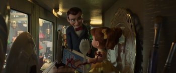 Movie still from “Toy Story 4” (2019), directed by Josh Cooley – A doll is holding a fork in front of a dummy; Medium shot, Over the shoulder angle