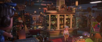 Movie still from “Toy Story 4” (2019), directed by Josh Cooley – An old doll is standing in front of a display case of antiques; Wide shot, High angle