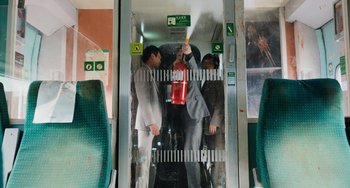 Movie still from “Train to Busan” (2016), directed by Yeon Sang-ho – Three men in suits and ties on a train; Wide shot, High angle