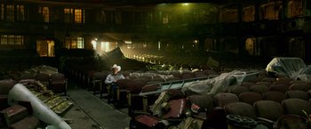 Movie still from “Transformers: Age of Extinction” (2014), directed by Michael Bay – A man sitting in a theater with a lot of bags on the floor; Wide shot, High angle