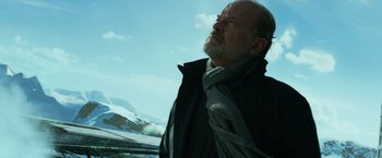 Movie still from “Transformers: Age of Extinction” (2014), directed by Michael Bay – An older man with a beard and a gray scarf; Medium shot, Low angle