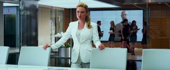 Movie still from “Transformers: Age of Extinction” (2014), directed by Michael Bay – A woman in a white suit standing in front of a table; Medium shot, Over the shoulder angle