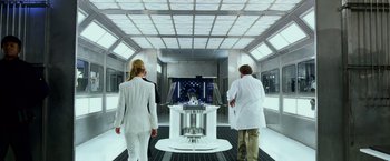 Movie still from “Transformers: Age of Extinction” (2014), directed by Michael Bay – Two men and a woman in white lab coats looking at an exhibit; Wide shot, Low angle