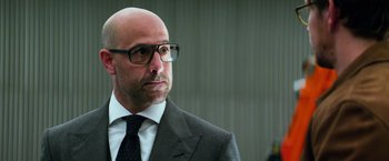 Movie still from “Transformers: Age of Extinction” (2014), directed by Michael Bay – A bald man in a suit and tie looking to his left; Close Up shot, Low angle