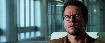 Movie still from “Transformers: Age of Extinction” (2014), directed by Michael Bay – A person wearing glasses sitting in a chair; Close Up shot, Over the shoulder angle