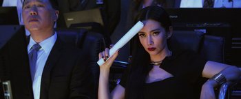 Movie still from “Transformers: Age of Extinction” (2014), directed by Michael Bay – A woman with long black hair holding a white object in front of her face; Close Up shot, Over the shoulder angle