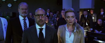 Movie still from “Transformers: Age of Extinction” (2014), directed by Michael Bay – A man and a woman standing next to each other in front of a group of people; Medium shot, Over the shoulder angle