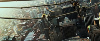 Movie still from “Transformers: Age of Extinction” (2014), directed by Michael Bay – A man hanging from a crane over a large city; Extreme Wide shot, Overhead angle