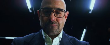 Movie still from “Transformers: Age of Extinction” (2014), directed by Michael Bay – A bald man wearing glasses and a white shirt; Close Up shot, Low angle