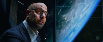 Movie still from “Transformers: Age of Extinction” (2014), directed by Michael Bay – A bald man wearing glasses looking at the camera; Close Up shot, Low angle