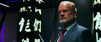 Movie still from “Transformers: Age of Extinction” (2014), directed by Michael Bay – An older man in a suit and tie looking to his left; Close Up shot, Low angle