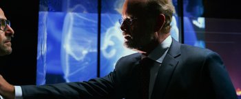 Movie still from “Transformers: Age of Extinction” (2014), directed by Michael Bay – A man in a suit and tie looking at the sky; Medium shot, Over the shoulder angle