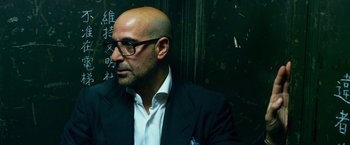 Movie still from “Transformers: Age of Extinction” (2014), directed by Michael Bay – A bald man wearing glasses and a suit; Close Up shot, Low angle