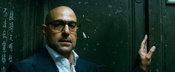 Movie still from “Transformers: Age of Extinction” (2014), directed by Michael Bay – A bald man wearing glasses and a suit; Close Up shot, Low angle