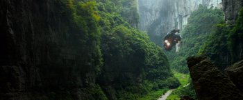 Movie still from “Transformers: Age of Extinction” (2014), directed by Michael Bay – A man flying through the air over a lush green forest; Extreme Wide shot, Low angle