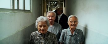 Movie still from “Transformers: Age of Extinction” (2014), directed by Michael Bay – A group of older women standing next to each other in a hallway; Medium shot, High angle