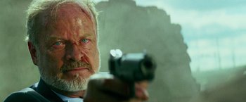 Movie still from “Transformers: Age of Extinction” (2014), directed by Michael Bay – An older man with a gun pointed at the camera; Close Up shot, Low angle