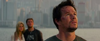 Movie still from “Transformers: Age of Extinction” (2014), directed by Michael Bay – Two men standing next to a body of water; Close Up shot, Over the shoulder angle