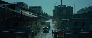 Movie still from “Transformers: Dark of the Moon” (2011), directed by Michael Bay – A truck driving down a street next to buildings; Extreme Wide shot, High angle