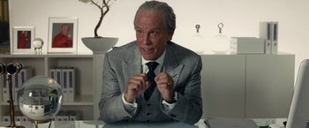 Movie still from “Transformers: Dark of the Moon” (2011), directed by Michael Bay – An older man wearing a suit and tie; Close Up shot, Over the shoulder angle
