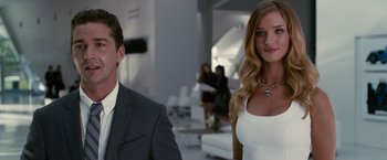 Movie still from “Transformers: Dark of the Moon” (2011), directed by Michael Bay – A man and a woman standing next to each other in a room; Medium shot, Over the shoulder angle