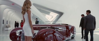 Movie still from “Transformers: Dark of the Moon” (2011), directed by Michael Bay – A woman standing next to an old fashioned car; Wide shot, Low angle
