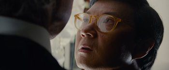 Movie still from “Transformers: Dark of the Moon” (2011), directed by Michael Bay – An older woman wearing glasses looking at the camera; Close Up shot, Over the shoulder angle