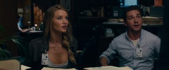 Movie still from “Transformers: Dark of the Moon” (2011), directed by Michael Bay – A beautiful young woman sitting at a table with other people; Close Up shot, Over the shoulder angle