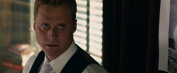 Movie still from “Transformers: Dark of the Moon” (2011), directed by Michael Bay – A person wearing a suit and tie; Close Up shot, Over the shoulder angle