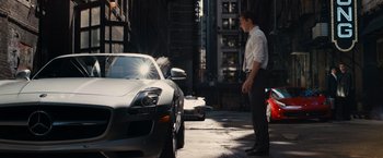 Movie still from “Transformers: Dark of the Moon” (2011), directed by Michael Bay – A man standing in front of a silver sports car; Wide shot, Over the shoulder angle