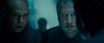 Movie still from “Transformers: Dark of the Moon” (2011), directed by Michael Bay – A person wearing a suit and tie; Close Up shot, Over the shoulder angle