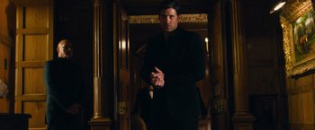 Movie still from “Transformers: Dark of the Moon” (2011), directed by Michael Bay – A man in a suit standing in front of a door; Medium shot, Over the shoulder angle