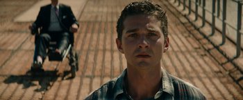 Movie still from “Transformers: Dark of the Moon” (2011), directed by Michael Bay – A young man standing in front of a brick walkway; Close Up shot, Low angle