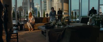 Movie still from “Transformers: Dark of the Moon” (2011), directed by Michael Bay – A group of people sitting around a living room with large windows; Wide shot, Over the shoulder angle