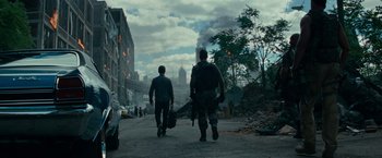 Movie still from “Transformers: Dark of the Moon” (2011), directed by Michael Bay – Two men walking down a street holding guns; Wide shot, Low angle