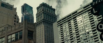 Movie still from “Transformers: Dark of the Moon” (2011), directed by Michael Bay – A tall building with smoke billowing out of it's windows; Extreme Wide shot, Low angle