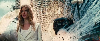 Movie still from “Transformers: Dark of the Moon” (2011), directed by Michael Bay – A woman standing in front of a wall with a car on top of it; Medium shot, Low angle