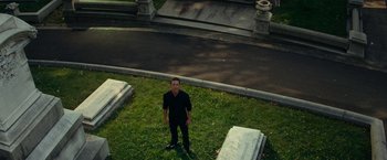 Movie still from “Transformers: Revenge of the Fallen” (2009), directed by Michael Bay – A man standing next to two graves in a cemetery; Wide shot, High angle