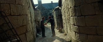 Movie still from “Transformers: Revenge of the Fallen” (2009), directed by Michael Bay – Two men standing in an alleyway holding a camera; Wide shot, Over the shoulder angle