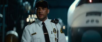 Movie still from “Transformers: Revenge of the Fallen” (2009), directed by Michael Bay – A man in a police uniform is holding a microphone; Close Up shot, Low angle