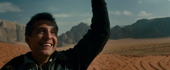Movie still from “Transformers: Revenge of the Fallen” (2009), directed by Michael Bay – A person waving at the camera in the desert; Close Up shot, Low angle
