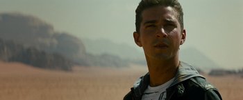 Movie still from “Transformers: Revenge of the Fallen” (2009), directed by Michael Bay – A person wearing a white t shirt; Close Up shot, Over the shoulder angle