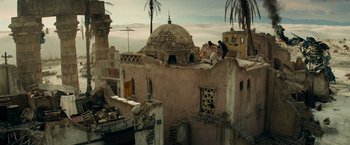 Movie still from “Transformers: Revenge of the Fallen” (2009), directed by Michael Bay – Two people are standing on the roof of an old building; Extreme Wide shot, Low angle