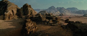 Movie still from “Transformers: Revenge of the Fallen” (2009), directed by Michael Bay – A group of people riding bikes on top of a rocky hill; Extreme Wide shot, High angle